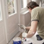 12433521 – painter working at door with white paint