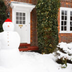 Snowman outside house