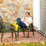 Happy woman relaxing autumn patio drinking tea