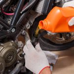 The process of pouring new oil into the motorcycle engine.